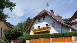 ein weißes Haus mit einem gelben Balkon in der Unterkunft Malerisches Bauernhaus in Lieserhofen