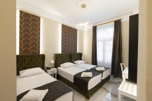 a hotel room with two beds and a television at Modern Revival Luxury Hotel in Thessaloniki