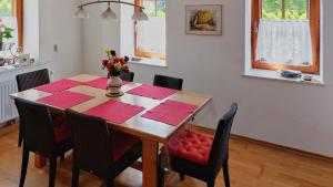 una mesa de comedor con servilletas rojas y un jarrón de flores en Malerisches Bauernhaus, en Lieserhofen