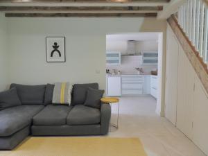 a living room with a couch and a kitchen at Grooms Cottage next to Sheriff Hutton Castle in Sheriff Hutton