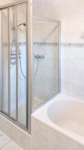 a white bathroom with a shower and a tub at Malerisches Bauernhaus in Lieserhofen