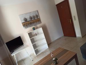 sala de estar con mesa y armario blanco en Green House Messini en Messini
