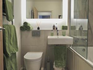 a bathroom with a sink and a toilet and a mirror at Grooms Cottage next to Sheriff Hutton Castle in Sheriff Hutton