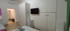 1 dormitorio con armarios blancos y TV en la pared en Maria in Vaticano, en Roma