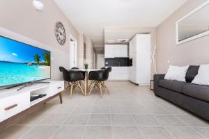 コスタ・カルマにあるSTAY SMART Fuerteventuraのリビングルーム(ソファ、テレビ、テーブル付)
