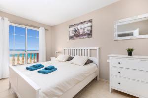 ein Schlafzimmer mit einem weißen Bett mit zwei blauen Handtüchern darauf in der Unterkunft STAY SMART Fuerteventura in Costa Calma + 43 Fotos