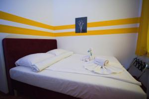 a bedroom with a white bed with yellow and black stripes at Hotel City Residence in Vienna