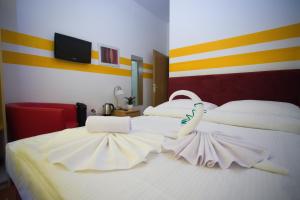 ウィーンにあるホテル シティ レジデンスの白いベッド2台(白鳥のベッド付)が備わるベッドルームです。
