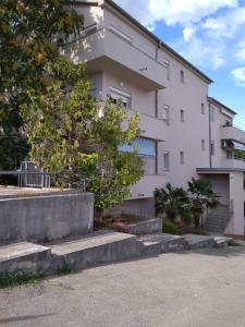 - un bâtiment blanc avec des escaliers devant dans l'établissement Apartman 4, à Rijeka