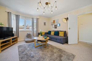 a living room with a couch and a tv at Stay In Cardiff Cathay's Terrace Apartment in Cardiff