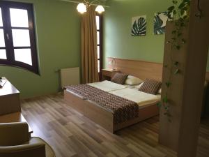ein kleines Schlafzimmer mit einem Bett und einem Fenster in der Unterkunft A Bárány in Kaposvár