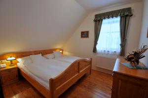 sypialnia z dużym drewnianym łóżkiem i oknem w obiekcie Doubické chalupy w mieście Doubice