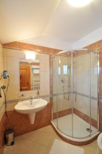uma casa de banho com uma cabina de duche em vidro e um lavatório. em Doubické chalupy em Doubice