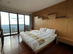 1 dormitorio con cama grande y ventana grande en Shi Home 1639, en Zhushan
