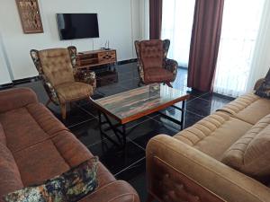 a living room with couches and a coffee table at Begonville Villas Ladies Beach in Kusadası