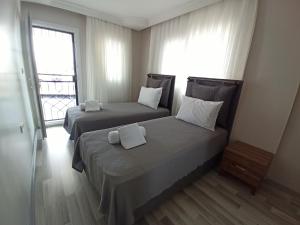 two beds in a room with a window at Begonville Villas Ladies Beach in Kusadası