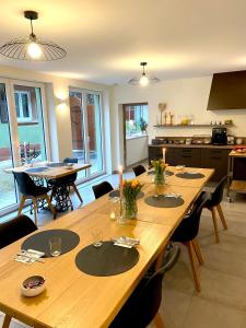 a dining room with a large wooden table with chairs at La Forge in Ringendorf