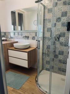 La salle de bains est pourvue d'une douche en verre et d'un lavabo. dans l'établissement Casa Levante, à Isola delle Femmine