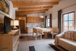 a kitchen and living room with a table and a couch at CHALET MARLENE - Ferienhaus in San Vigilio Di Marebbe