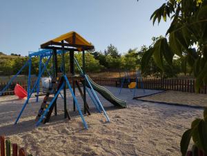 un parque infantil con un tobogán en la arena en Casas Rurales Campolibre, en Masegoso