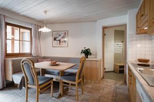 a kitchen and dining room with a table and chairs at CHALET MARLENE - Ferienhaus in San Vigilio Di Marebbe