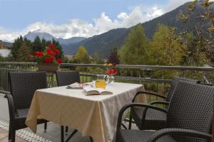 a table on a balcony with a view of mountains at CHALET MARLENE - Ferienhaus in San Vigilio Di Marebbe