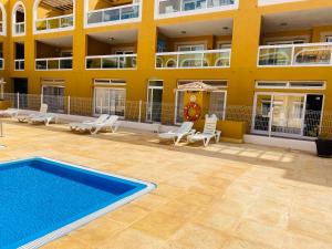 a building with a swimming pool in front of a building at Faro beach&pool in Cotillo