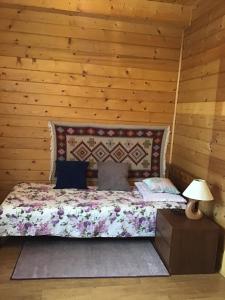 łóżko w pokoju z drewnianą ścianą w obiekcie Jankówka w Wieliczce