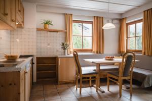 a kitchen with a table and chairs in a room at CHALET MARLENE - Ferienhaus in San Vigilio Di Marebbe