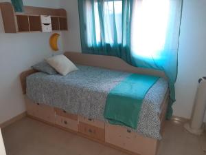 a bed in a room with a window and a bed with a box at Viajeros in Las Lagunas