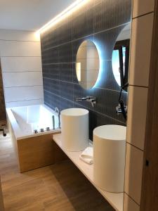 a bathroom with two sinks and a bath tub at HOTEL MONTE PERDIDO in Bielsa +42 photos