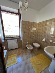 a bathroom with a toilet and a sink at Casa Caterina 2 storey house, with a mountain view in Toscolano Maderno