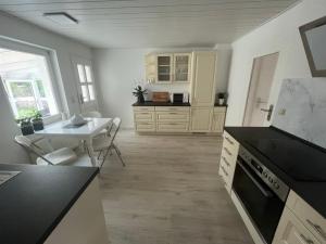 a kitchen with a table and a dining room at Familienfreundliche Ferienwohnung mit Wintergarten in Badow