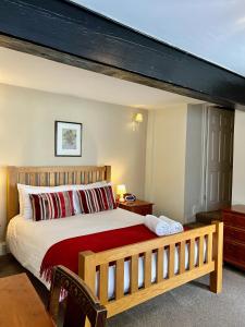 sypialnia z dużym łóżkiem z drewnianą ramą w obiekcie The Kings Arms Inn w mieście Oakham