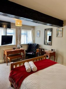 a bedroom with a bed and a living room at The Kings Arms Inn in Oakham