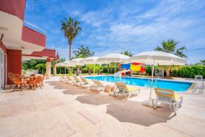 阿拉尼亞的住宿－MİKADO BEACH HOTEL，一个带桌椅和遮阳伞的游泳池