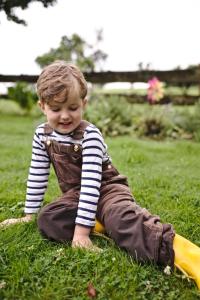a young boy sitting on a toy in the grass at Hotel-Restaurant Im Heisterholz in Hemmelzen
