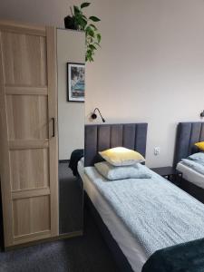 een slaapkamer met een bed en een deur met een spiegel bij Apartamenty CITI in Siechnice