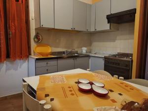 una cucina con tavolo in legno e una cucina con lavandino di Casetta Petrara a Tiriolo