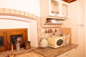 a kitchen with a microwave and a fireplace at Casa alle Monache in Gambassi Terme