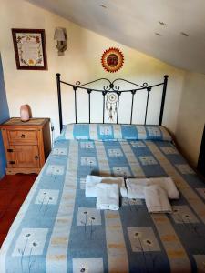 a bedroom with a large bed with a blue blanket at Casa del Águila del Valle in Riópar Viejo