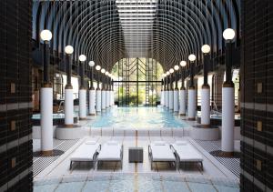 a pool in a building with white tables and chairs at Victoria Jungfrau Grand Hotel & Spa in Interlaken