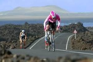 two people riding their bikes on a road at Elena Beach House Lanzarote in Playa Honda
