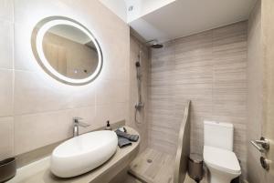uma casa de banho com um lavatório branco e um espelho. em VATHI SPIROS VILLAS em Agios Nikolaos