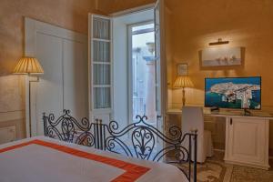 a bedroom with a bed and a window at Palazzo Mosco Inn - Dimora Storica in Gallipoli