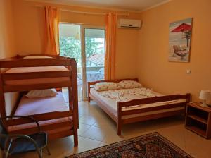 a bedroom with two bunk beds and a balcony at Sinanovic Rooms in Ulcinj
