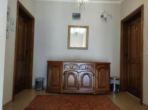 a wooden cabinet in a room with a mirror at Sinanovic Rooms in Ulcinj