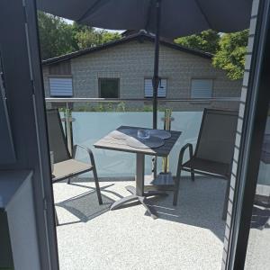 a table and two chairs and an umbrella on a patio at Apartment 28 in Stadthagen