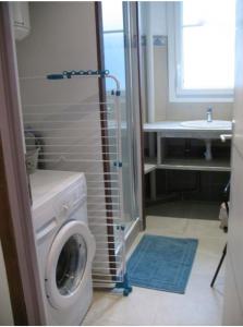 a bathroom with a washing machine and a sink at Appartement meublé 52m2 in Bagnères-de-Bigorre +13 photos