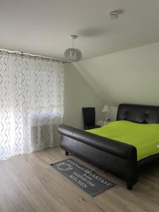 ein Schlafzimmer mit einem schwarzen Bett und einer grünen Decke in der Unterkunft Apartment 28 in Stadthagen